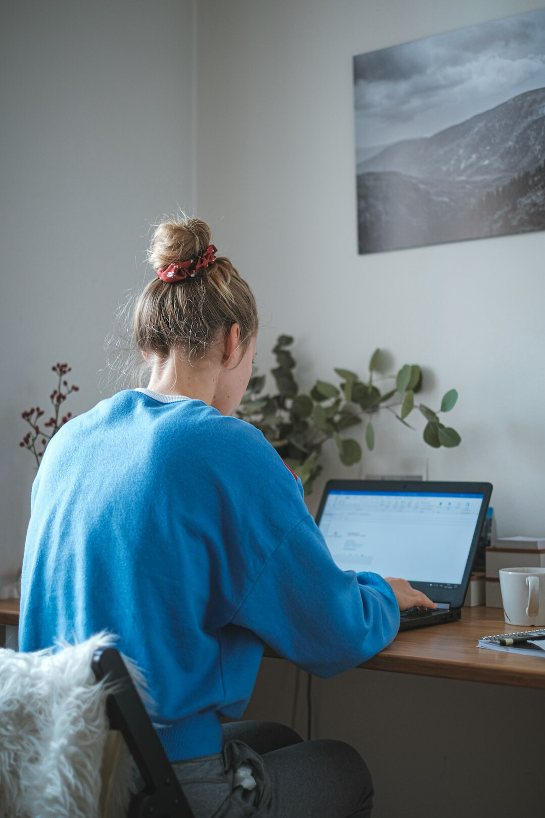 student coding on laptop at desk