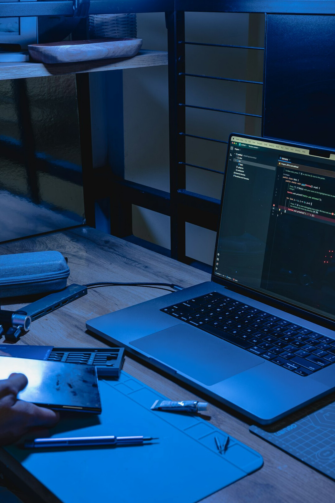 student coding on laptop at desk